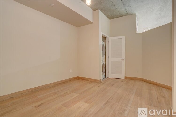 A room with wooden flooring and a doorway leading to another room.