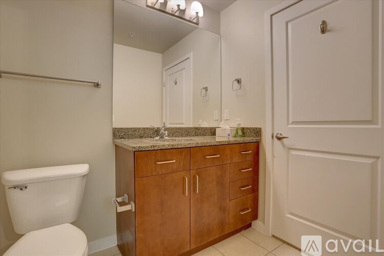A bathroom with a toilet, sink, and mirror.