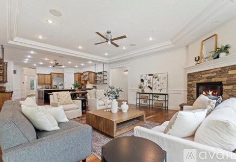 A living room with a grey couch and a fireplace.