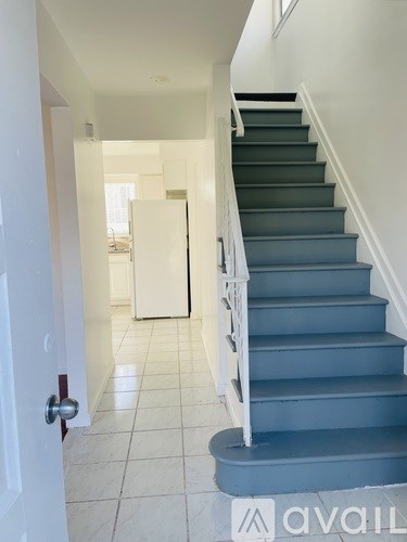 A staircase with a white railing and a white door at the bottom.