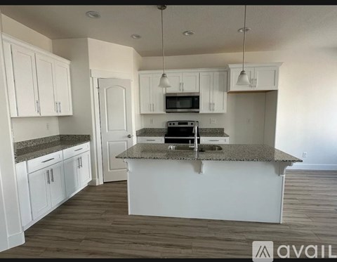 A kitchen with white cabinets and a granite countertop.
