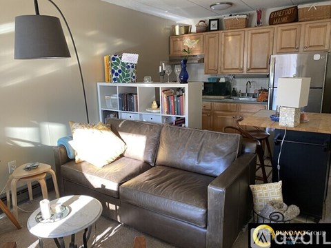 A living room with a brown leather couch and a white coffee table.