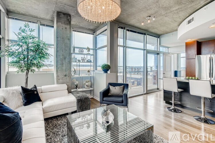 A modern living room with a glass table and white couches.