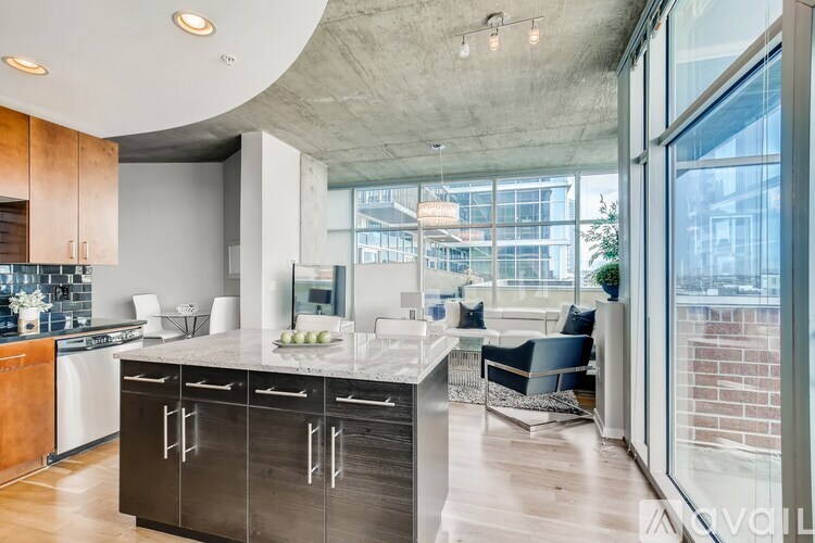 A modern kitchen with a marble countertop and a view of the city.