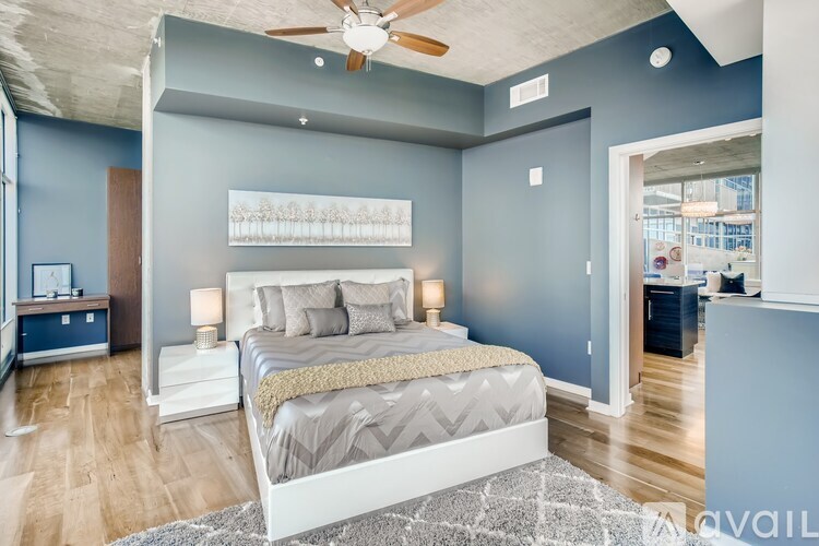 A bedroom with a bed, nightstands, and a ceiling fan.