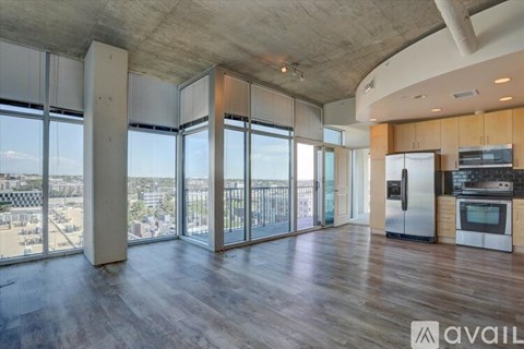 A spacious kitchen with wooden floors and a view of the city.