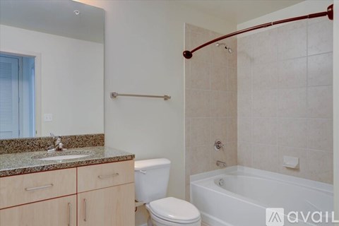 A bathroom with a tub, toilet, and sink.