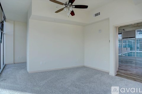 A room with a ceiling fan and a carpeted floor.