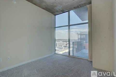 A room with a large window overlooking a cityscape.