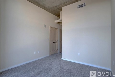 A room with a door and a carpeted floor.