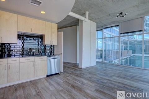 A kitchen with wooden cabinets and a large window.