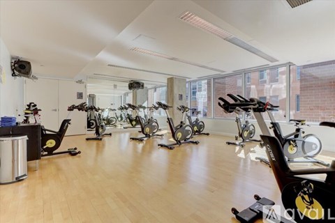 A room full of exercise bikes and a TV mounted on the wall.