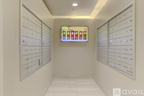 A hallway with white walls and a row of mailboxes on either side.
