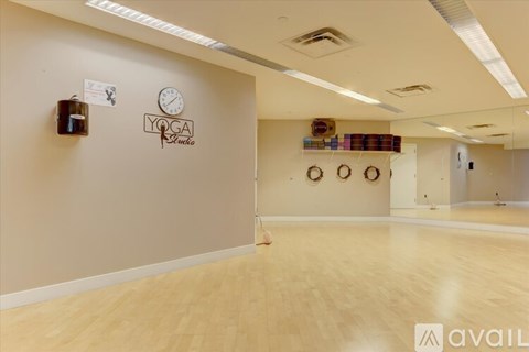A yoga studio with wooden floors and a clock on the wall.