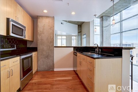 A kitchen with wooden cabinets and a black countertop.