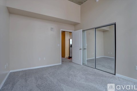 A spacious room with a carpeted floor and a sliding glass door.