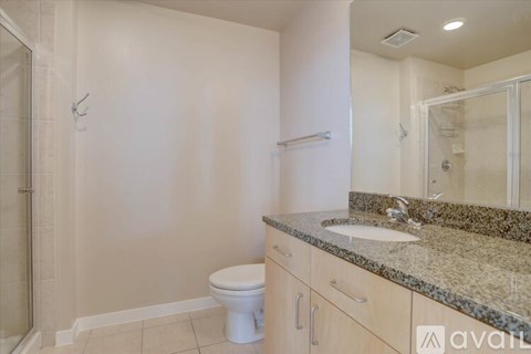 A bathroom with a toilet, sink, and shower.