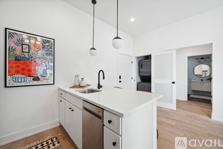 A kitchen with white cabinets and a framed picture on the wall.