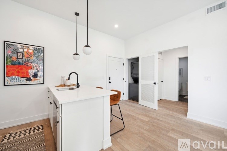A kitchen with a white island and a painting on the wall.