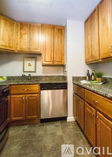 A kitchen with wooden cabinets and a granite countertop.