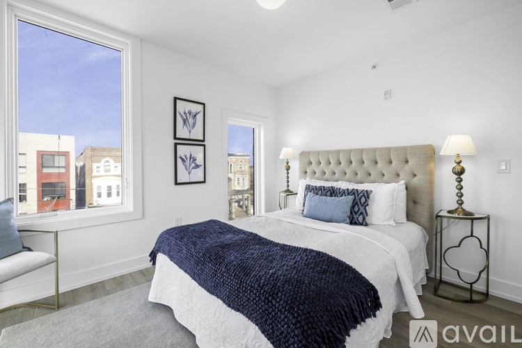A bedroom with a large bed and a window overlooking the city.