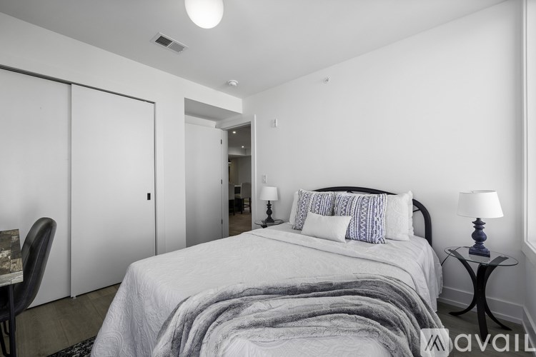 A bedroom with a bed, a chair, and a lamp.