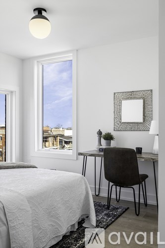 A bedroom with a bed, desk, and chair.