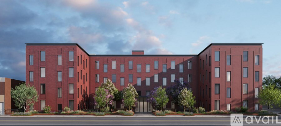 A large red brick building with trees in front.