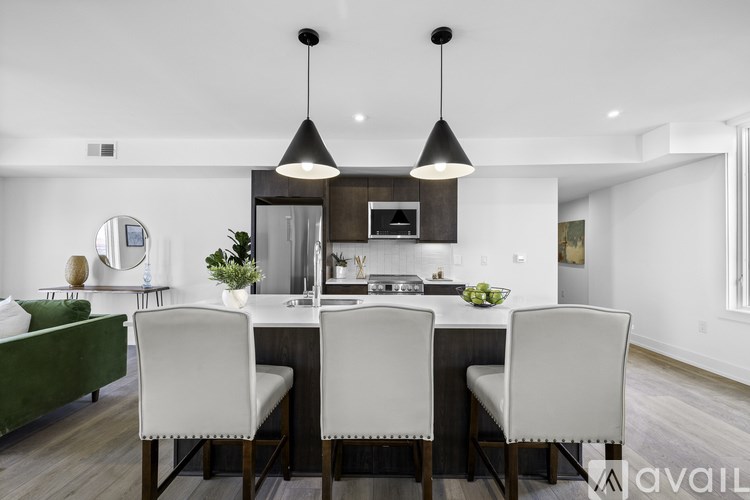 A modern dining room with a dark wood table and white chairs.