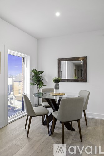 A dining room with a table and chairs and a large mirror on the wall.