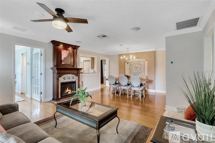 A living room with a fireplace and a glass coffee table.