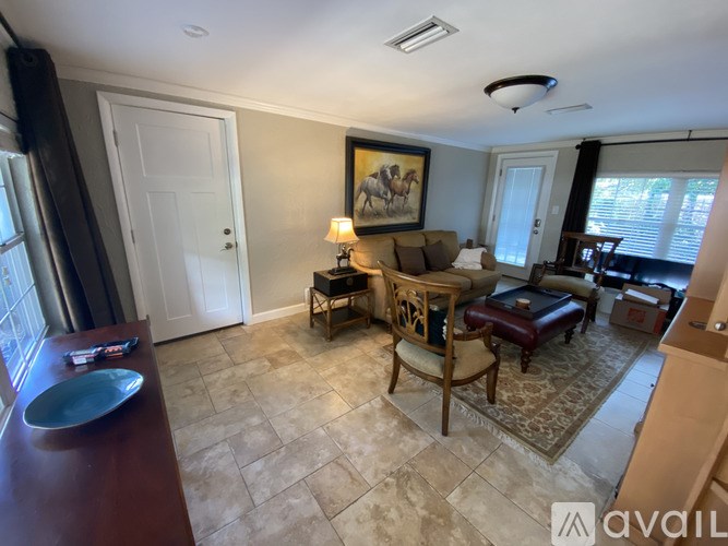 A living room with a painting on the wall and a couch.