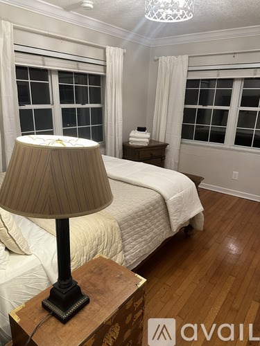 A bedroom with a bed, nightstand, and lamp.