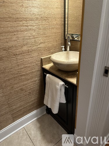 A bathroom sink with a towel hanging on the side.