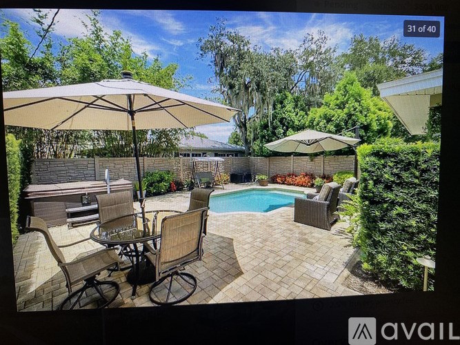 A patio with a table and chairs and an umbrella is shown.