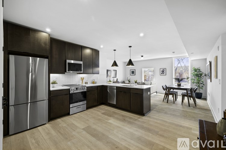 A modern kitchen with dark wood cabinets and stainless steel appliances.