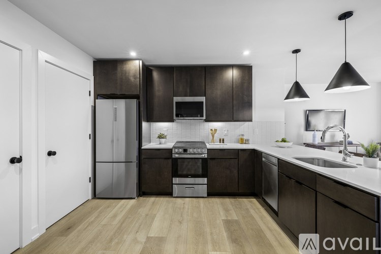 A modern kitchen with dark wood cabinets and stainless steel appliances.