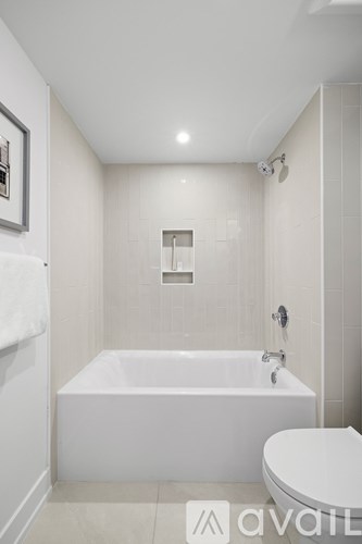 A white bathroom with a tub and toilet.