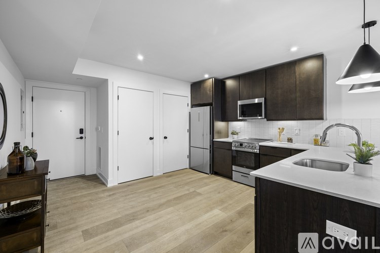 A modern kitchen with dark wood cabinets and a white countertop.