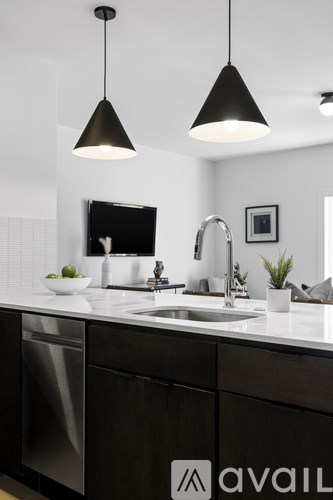 A modern kitchen with a sink, dishwasher, and a mirror.