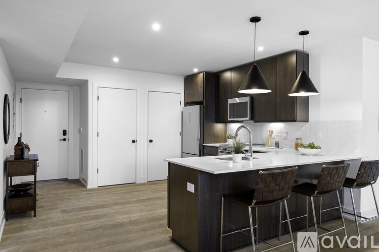 A modern kitchen with a central island and bar stools.