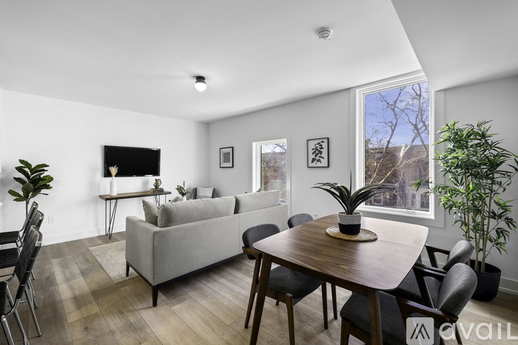 A living room with a grey couch, a wooden table, and a television.