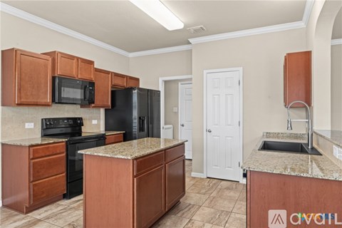 A kitchen with brown cabinets and black appliances.