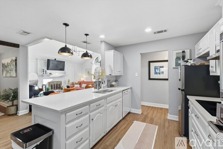 A modern kitchen with white cabinets and a black fridge.