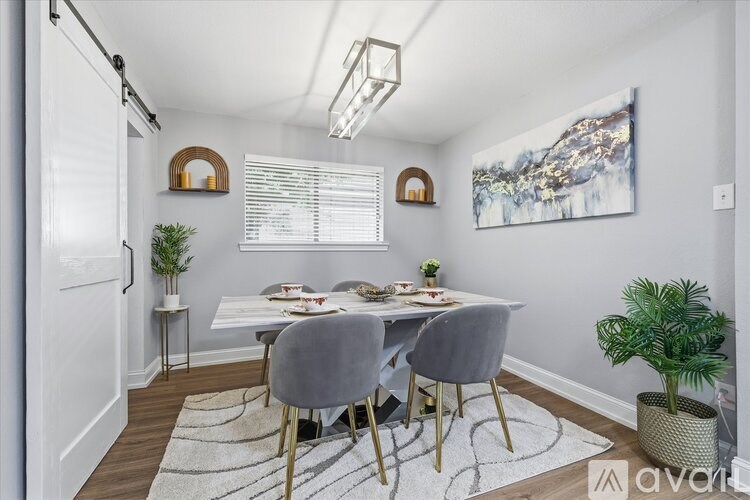 A dining room with a white table and grey chairs.