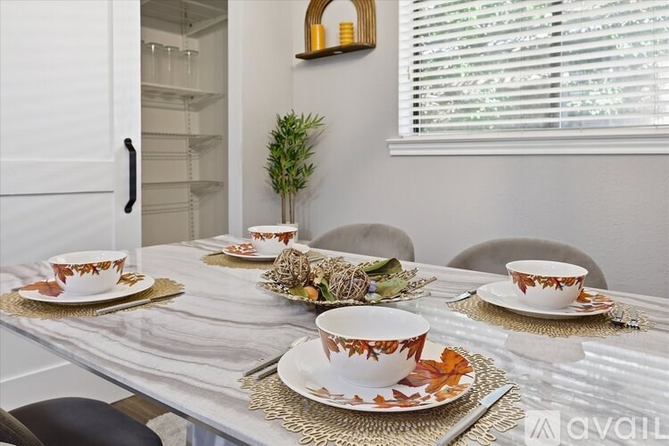 A table set for a meal with a plant in the background.