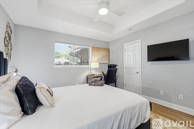 A bedroom with a bed, a chair, and a television.
