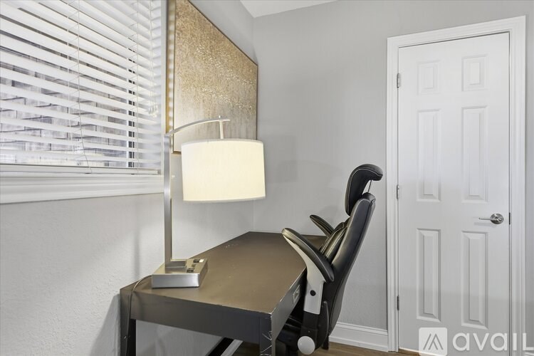 A table with a lamp and a chair in a room.