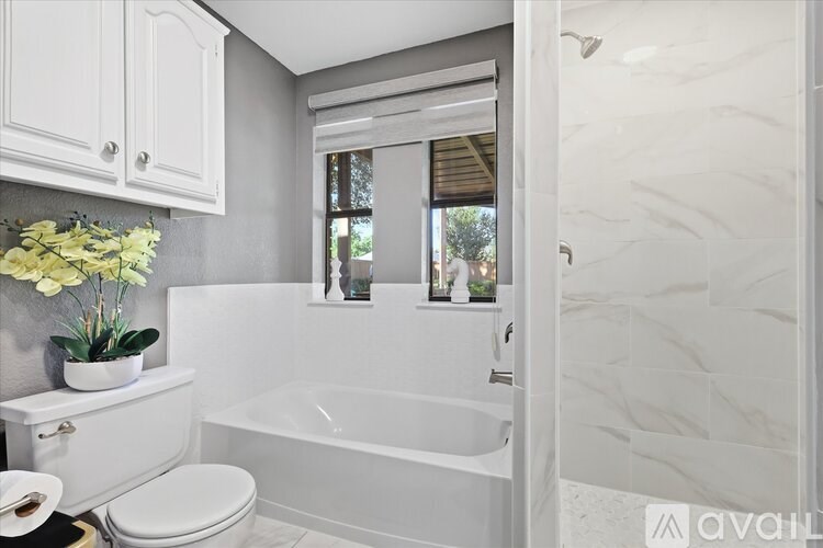 A white bathroom with a tub, toilet, and sink.