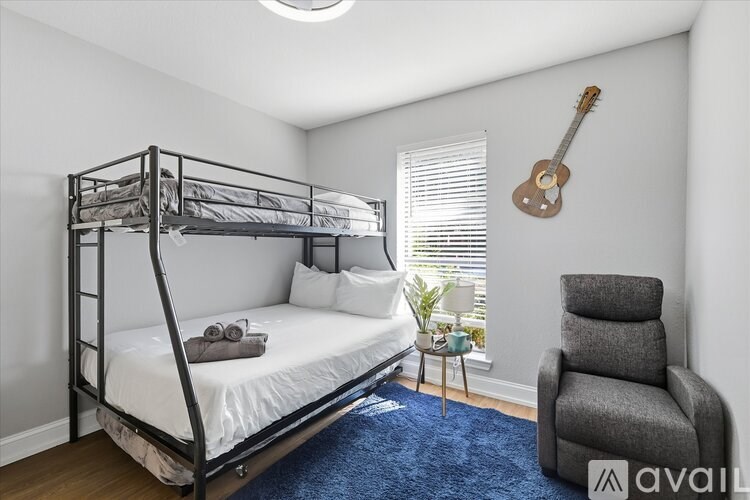 A bedroom with a bunk bed and a chair.